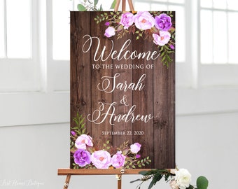 May include: A rustic wooden wedding welcome sign with purple and pink flowers. The sign reads "Welcome to the wedding of Sarah & Andrew September 22, 2020".