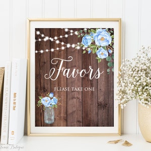 May include: A rustic wooden sign with blue flowers and string lights, reading "Favors Please Take One".
