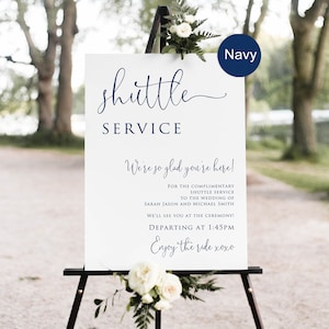 May include: A white sign with blue text on an easel. The sign reads "shuttle service" and provides information about a complimentary shuttle service to the wedding of Sarah Jason and Michael Smith. The shuttle departs at 1:45 PM. The sign also says "We're so glad you're here!" and "Enjoy the ride xoxo".