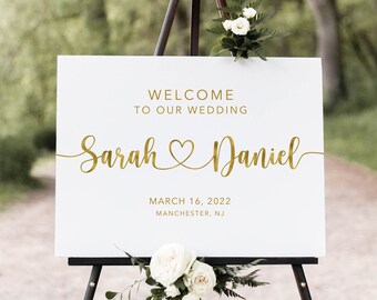 May include: White wedding welcome sign with gold lettering. The sign reads "Welcome to our wedding Sarah & Daniel March 16, 2022 Manchester, NJ".