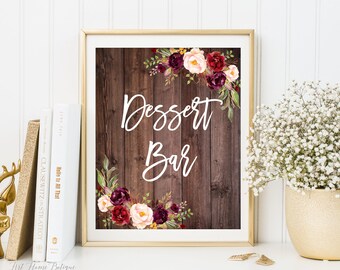 May include: Printable sign with a rustic wood background and floral accents. The sign says "Dessert Bar" in white script font.