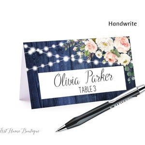 May include: A blue and white wedding place card with a floral design and string lights. The card says "Olivia Parker, Table 3".