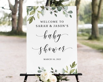 May include: White welcome sign with green foliage and the text "Welcome to Sarah & Jason's baby shower March 16, 2022".