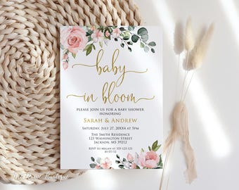 May include: A baby shower invitation with a floral design and gold lettering. The text reads "baby in bloom" and includes the details of the event, including the date, time, location, and RSVP information.