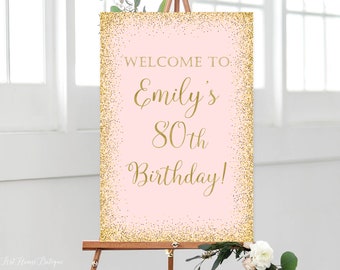 May include: Pink and gold welcome sign with the text "Welcome to Emily's 80th Birthday!"