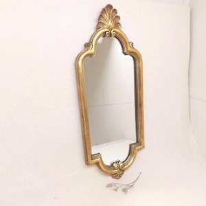 May include: A white ceramic mug with a black handle and the text "But First, Coffee" in a black, bold font. The mug is on a white surface. The mug is approximately 10 cm tall.