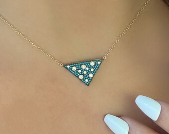 May include: A gold chain necklace with a turquoise and white triangle pendant.