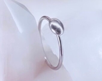 May include: A simple silver ring with a small, round, silver bead on the top.