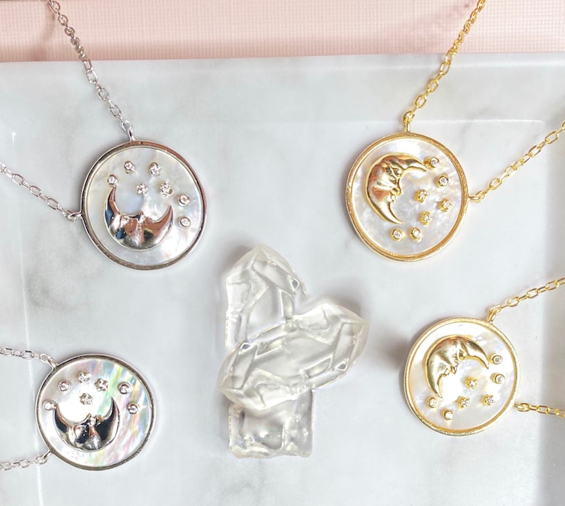Puede incluir: Cuatro collares con cadenas de plata y oro y colgantes de luna y estrella. Los colgantes est&aacute;n hechos de madreperla blanca con una luna creciente plateada u dorada y peque&ntilde;as piedras blancas.