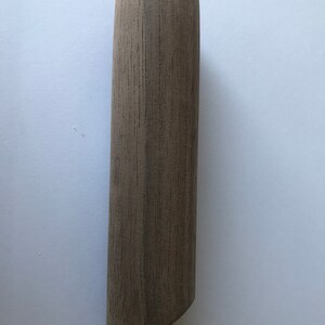 May include: A cylindrical wooden dowel with a light brown color and a slightly rounded top.