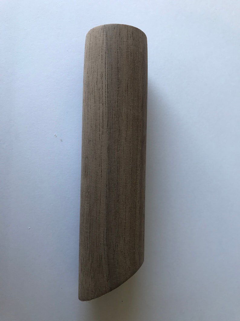 May include: A cylindrical wooden dowel with a light brown color and a slightly rounded top.