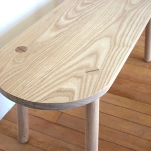 Custom made solid Ash bench seat with rounded ends made with four straight turned legs  fixed into position with contrasting timber wedges