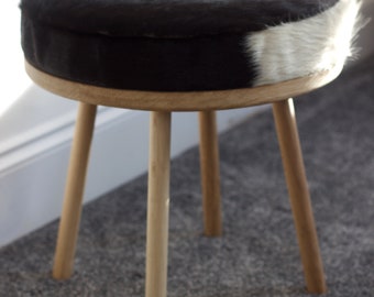 Cowhide round European Oak footstool with straight turned legs upholstered in natural cowhide