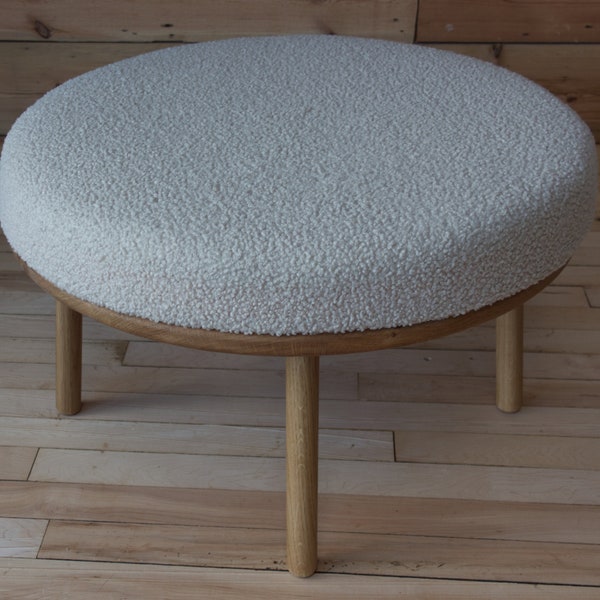 Round boucle footstool made with a solid oak base with four turned legs as bd a padded cushion upholstered in a heavy chunky boucle fabric