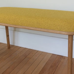 Handmade solid oak bench with rounded ends and four turned straight legs upholstered in 100% recycled chemical free Boucle Fabric