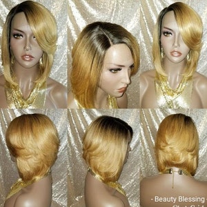Op de afbeelding: Een kort, recht, blond bob-pruik met donkere wortels. De pruik is gestyled met een scheiding aan de zijkant en een zijwaarts geveegde pony. De pruik wordt gedragen op een mannequinhoofd.