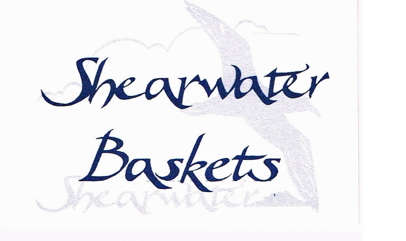 May include: A white background with a blue cursive logo that reads "Shearwater Baskets" with a stylized seagull image above the text.