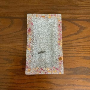 May include: A rectangular white tray with a pink and gold glitter border. The tray has a small rectangular indentation in the center.