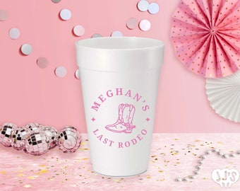 May include: White foam cup with a pink design that says "Meghan's Last Rodeo" with a pair of pink cowboy boots in the center.