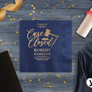 May include: Blue paper napkin with gold text that reads "Class of 202X Case Closed!" with a gavel graphic. The text below reads "Robert Hamilton Texas A&M University School of Law".