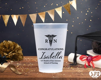 May include: A white plastic cup with a black and white medical symbol, the letters "RN", and the text "CONGRATULATIONS Isabella UT Health of San Antonio School of Nursing".