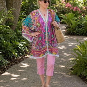 Turquoise pink paisley silk kaftan top worn with pink capri pants and straw tote at botanical gardens.
