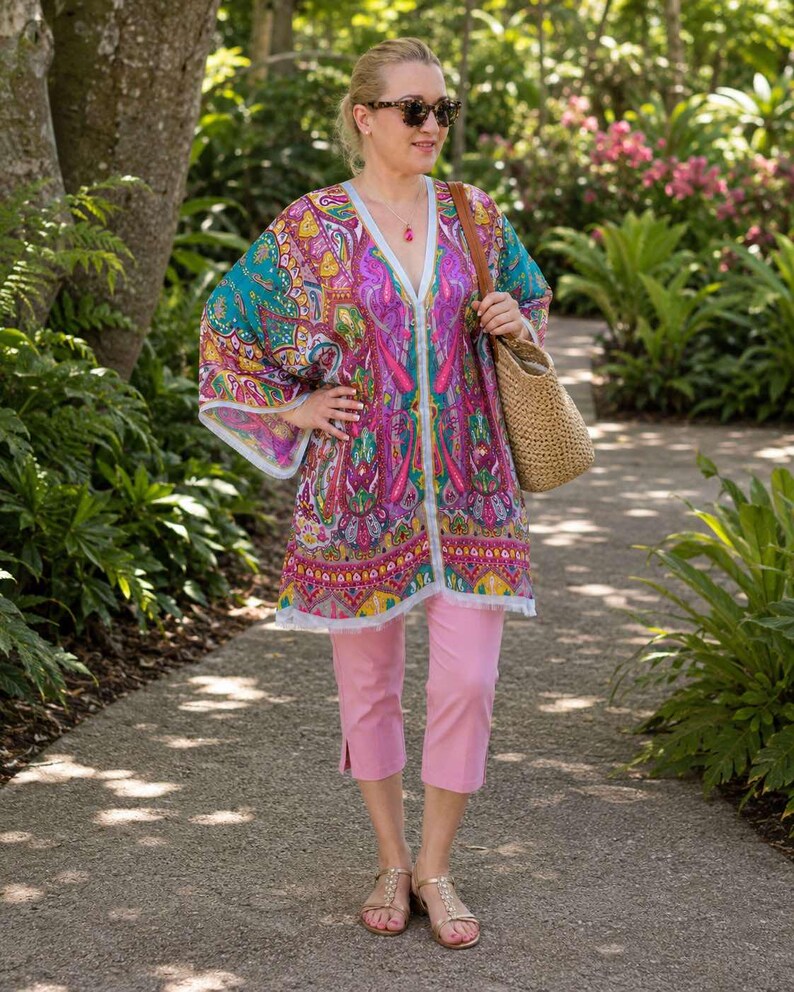 Turquoise pink paisley silk kaftan top worn with pink capri pants and straw tote at botanical gardens.