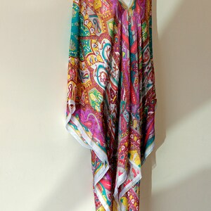 May include: A colorful paisley patterned tunic with a V-neckline. The tunic is made of a lightweight fabric and has a flowing silhouette.