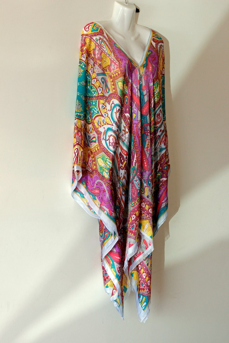 May include: A colorful paisley patterned tunic with a V-neckline. The tunic is made of a lightweight fabric and has a flowing silhouette.