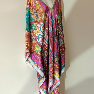 May include: A colorful paisley patterned tunic with a V-neckline. The tunic is made of a lightweight fabric and has a flowing silhouette.