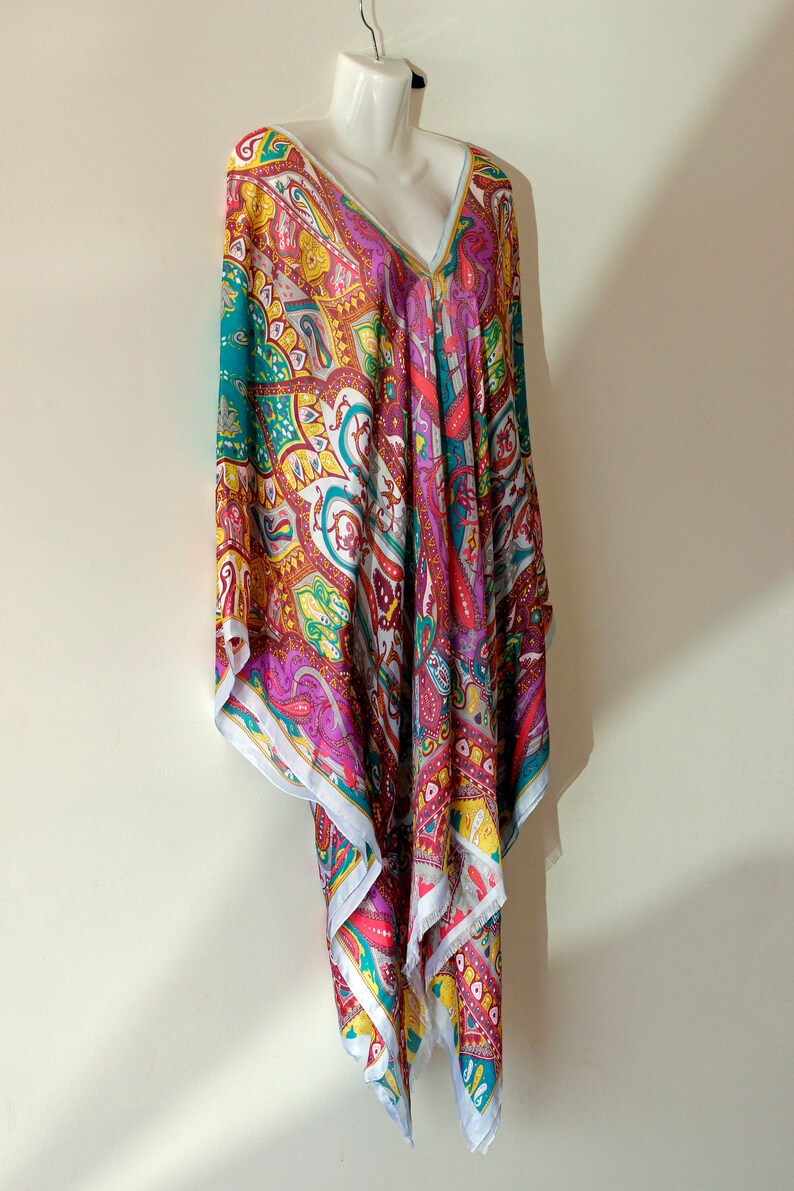 May include: A colorful paisley patterned tunic with a V-neckline. The tunic is made of a lightweight fabric and has a flowing silhouette.