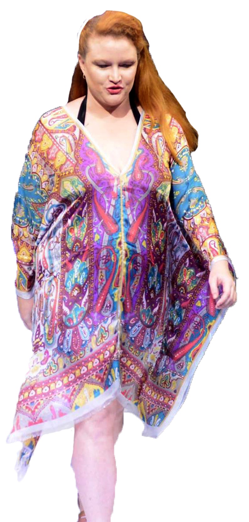 May include: A woman wearing a colorful, patterned, long-sleeved dress with a V-neckline. The dress has a paisley design with shades of blue, purple, red, yellow, and white.