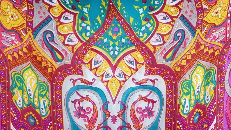 May include: A fabric textile featuring a vibrant, symmetrical paisley pattern in shades of teal, magenta, bright yellow, and white. The design consists of intricate teardrop shapes, floral motifs, and geometric borders arranged in a repeating layout.