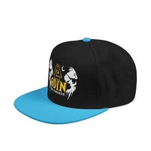 May include: Black and blue baseball cap featuring a graphic of Odin, with the text "ODIN THE WANDERER" in yellow and white. The cap has a blue brim and a blue button on top.