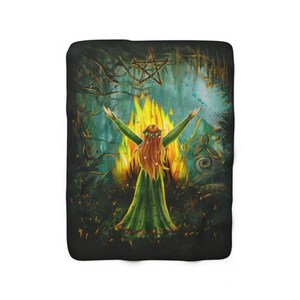 May include: A woman with long red hair stands in front of a fire with her arms raised. She is wearing a green dress and a flower crown. A pentagram hangs above her in the dark forest.