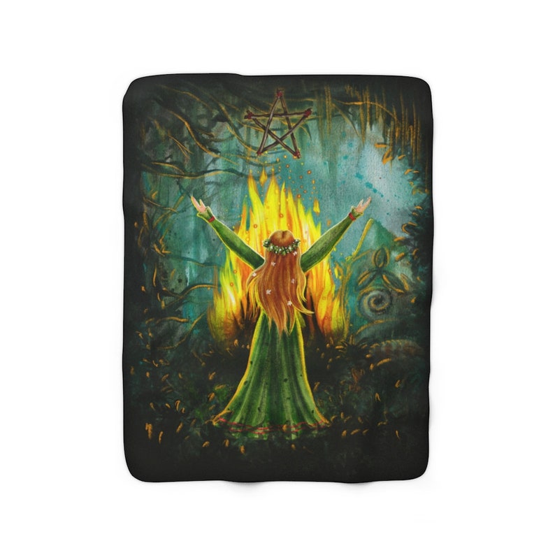 May include: A woman with long red hair stands in front of a fire with her arms raised. She is wearing a green dress and a flower crown. A pentagram hangs above her in the dark forest.