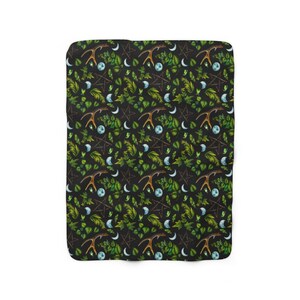 May include: A black and green patterned fleece blanket with a repeating design of antlers, crescent moons, pentacles, and leaves.
