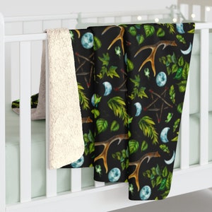 May include: A black and green fleece throw blanket with a repeating pattern of antlers, crescent moons, leaves, and pentagrams.