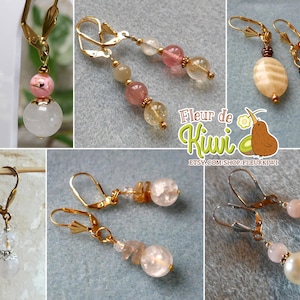 May include: Assortment of handmade earrings featuring various gemstone beads, including pink, white, and brown. The earrings are made with gold and silver findings. The earrings are displayed on a white background.