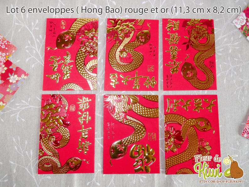 Op de afbeelding: Zes rode en gouden enveloppen met een slangendesign en Chinese karakters. De enveloppen zijn 11,3 cm bij 8,2 cm.