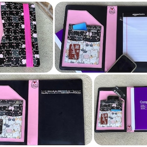 May include: Black and pink portfolio with a cat pattern. The portfolio has a pink accent and a pocket with a cat pattern. The portfolio is open, revealing a notepad, a phone, and a purple notebook.