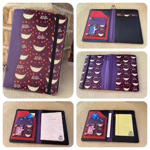May include: Purple and burgundy Alice in Wonderland themed portfolio. The cover features a repeating pattern of Cheshire Cat smiles and the text "We're All Mad Here." The interior includes pockets, card slots, and a notepad.