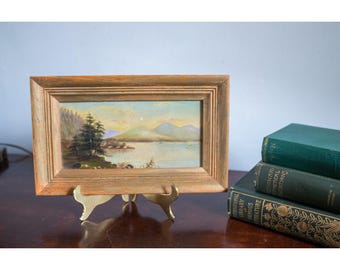 Paesaggio antico incorniciato con montagna, lago, tramonto, pini e cornice in legno anticato.