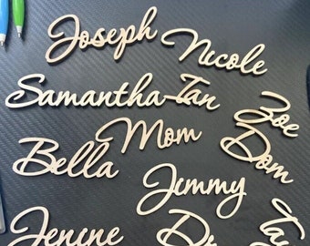 May include: A collection of wooden name signs with cursive lettering. The names include Joseph, Nicole, Samantha-Tan, Bella, Mom, Jimmy, Dre, Katelyn, Taylor, Joe, Dom, and Edmun.