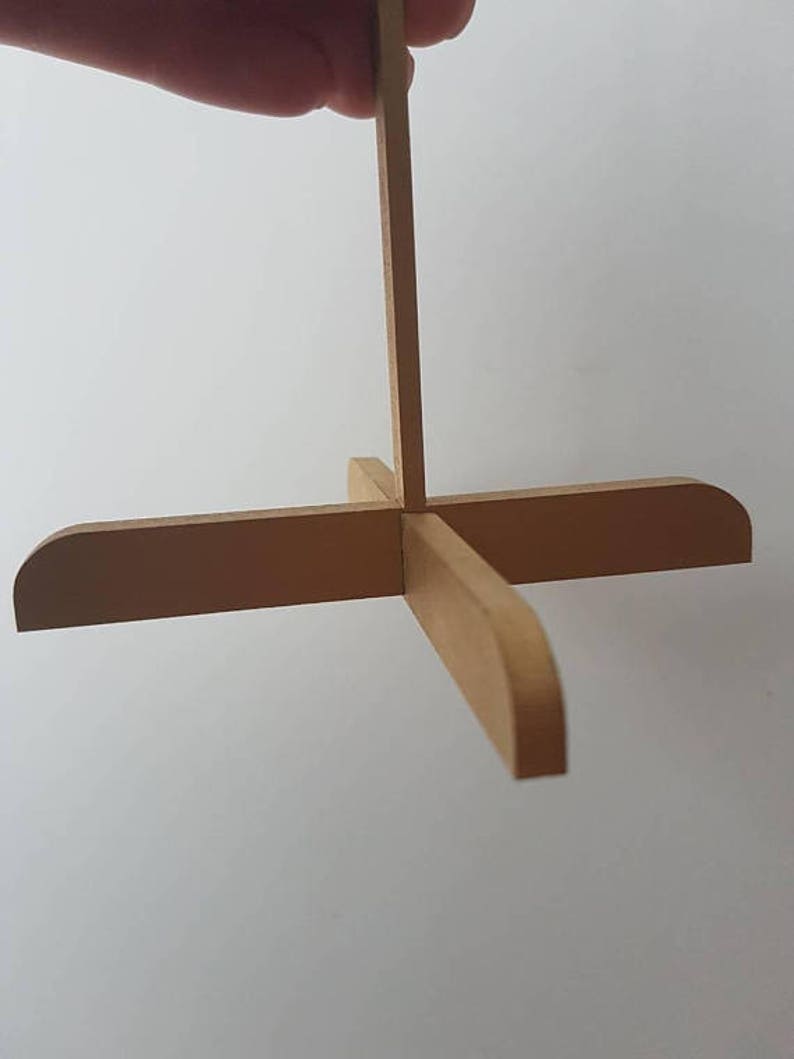 Op de afbeelding: Een houten standaard met vier poten en een verticale steun. De standaard is gemaakt van lichtbruin hout en heeft een eenvoudig ontwerp.
