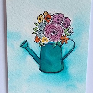Könnte beinhalten: Aquarellmalerei eines türkisfarbenen Gießkannen mit bunten Blumen. Die Blumen umfassen rosa, orange, gelbe und weiße Blüten. Der Hintergrund ist eine hellblaue Aquarellwäsche. Das Wort "HELLO" ist unten in Schwarz geschrieben.