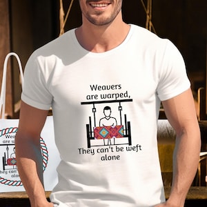 May include: White t-shirt and tote bag with the text "Weavers are warped, they can't be weft alone." The shirt and bag feature a graphic of a person at a loom. The tote bag has a red and blue rope design around the text.