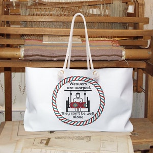 May include: White tote bag with a red, white, and blue rope design and the text "Weavers are warped, They can't be weft alone".