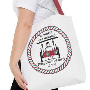 Könnte beinhalten: Weiße Einkaufstasche mit einem roten und blauen Seil-Design um eine Grafik einer Person, die an einem Webstuhl webt. Der Text lautet "Weavers are warped, They can't be weft alone."