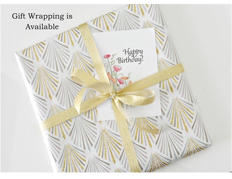 May include: A white gift box with a gold and gray geometric pattern. The box is wrapped with a gold ribbon and a white card that says "Happy Birthday!"